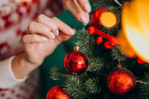 manos femeninas cerca decorando arbol navidad bolas rojas 1303 18257