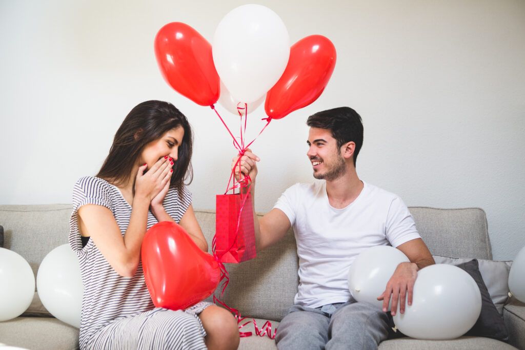 hombre entregando su novia globos bolsa roja scaled