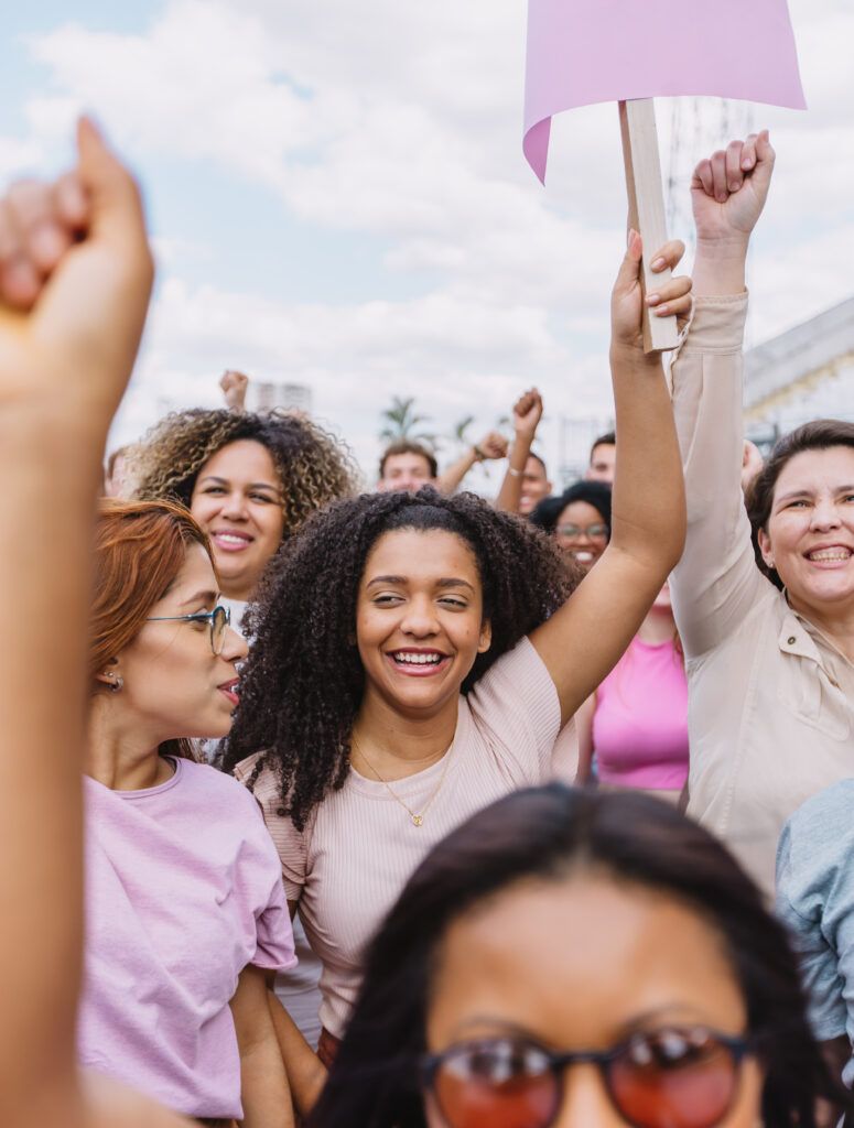 Group of varied people protesting with hands up. Vertical photo.